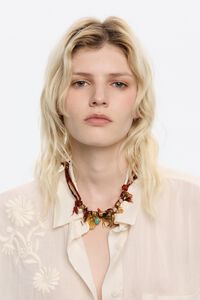 Collar tejido trenzado con motivos metal dorado